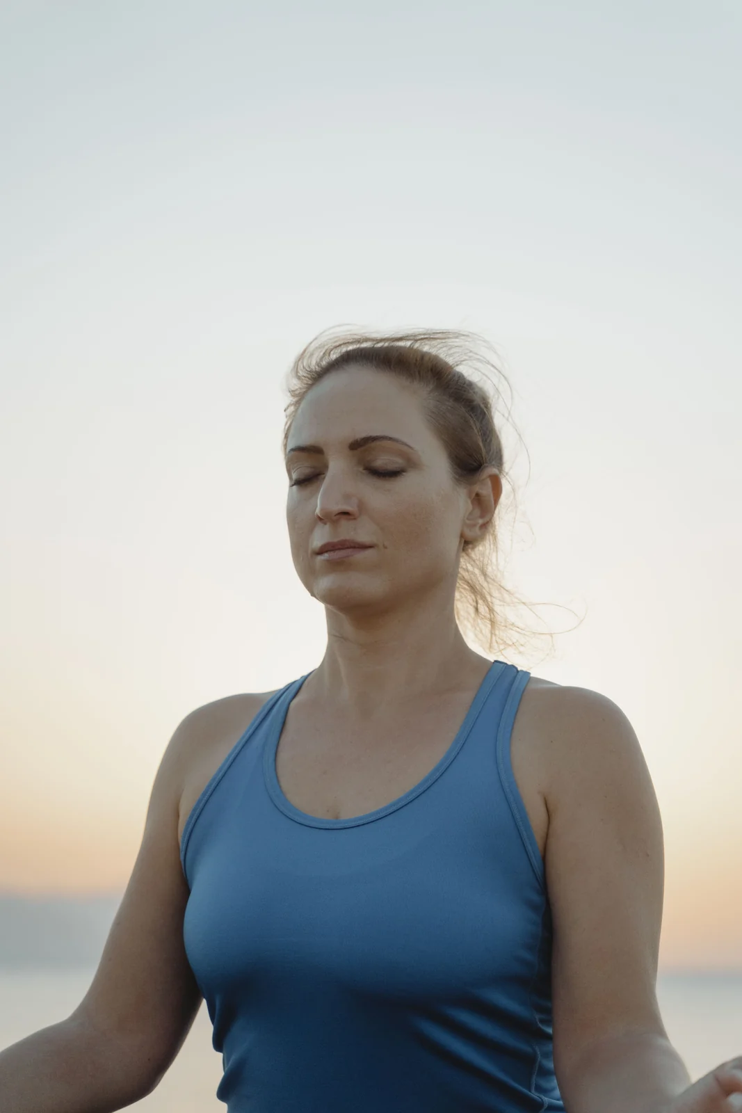 A woman with her eyes closed in early sunlight
