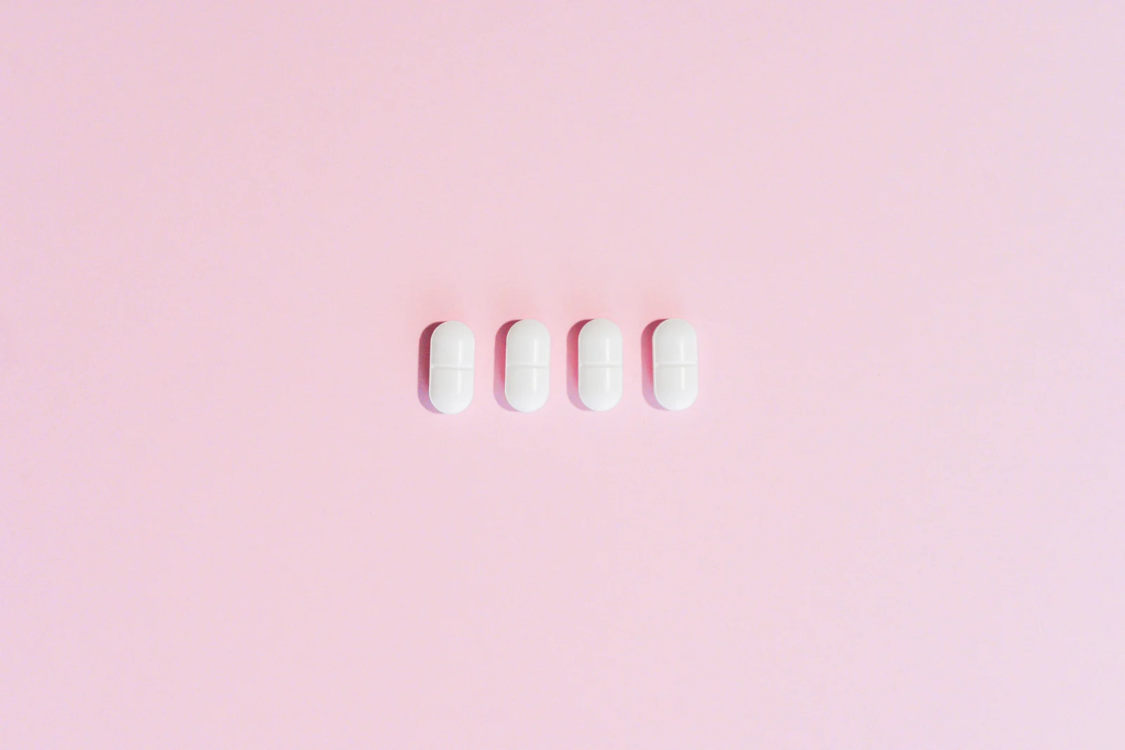 Four capsules laid out on a plain surface